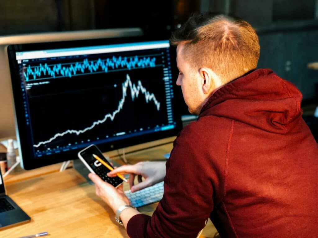 Man investing with an investment graph on a computer screen