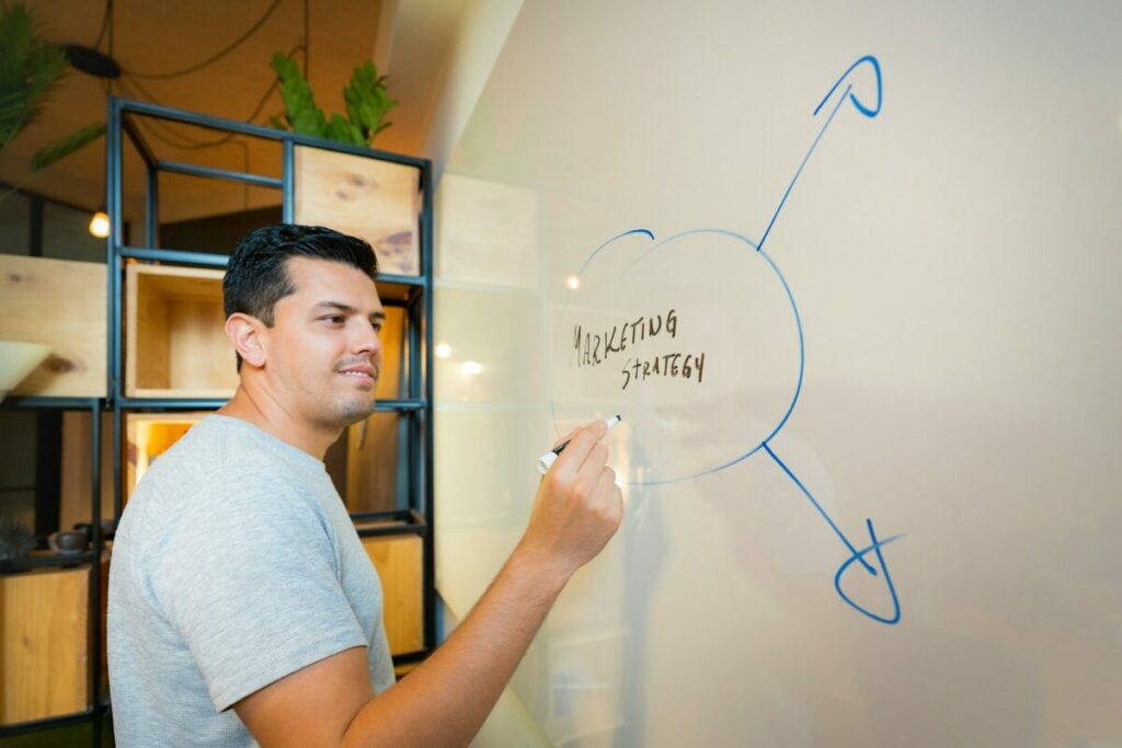 Man writing a Marketing Strategy Plan on a whiteboard